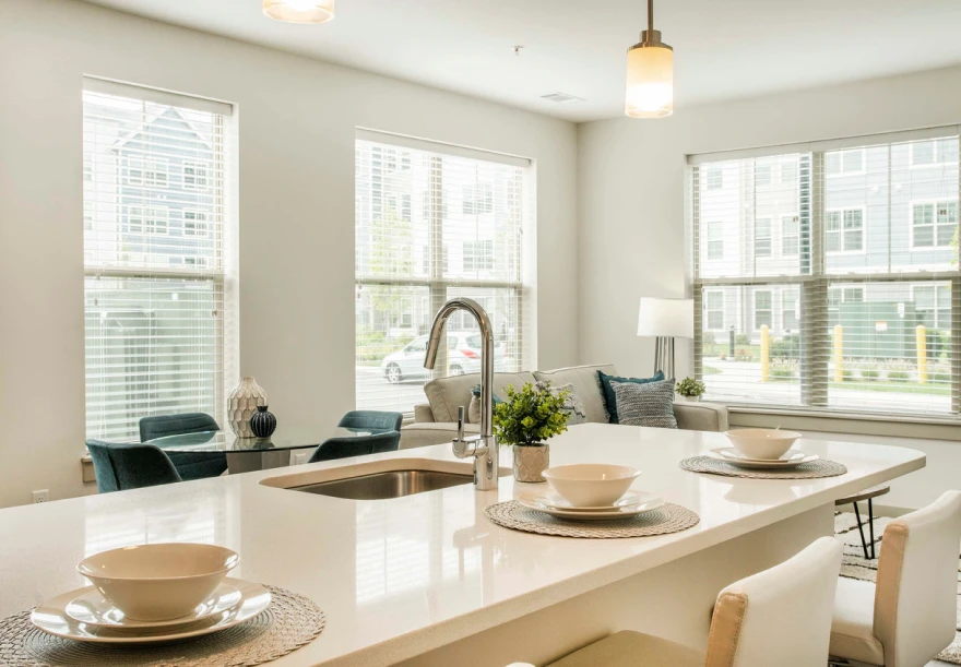 Open-concept kitchen and living space with bright windows and bar-style seating area