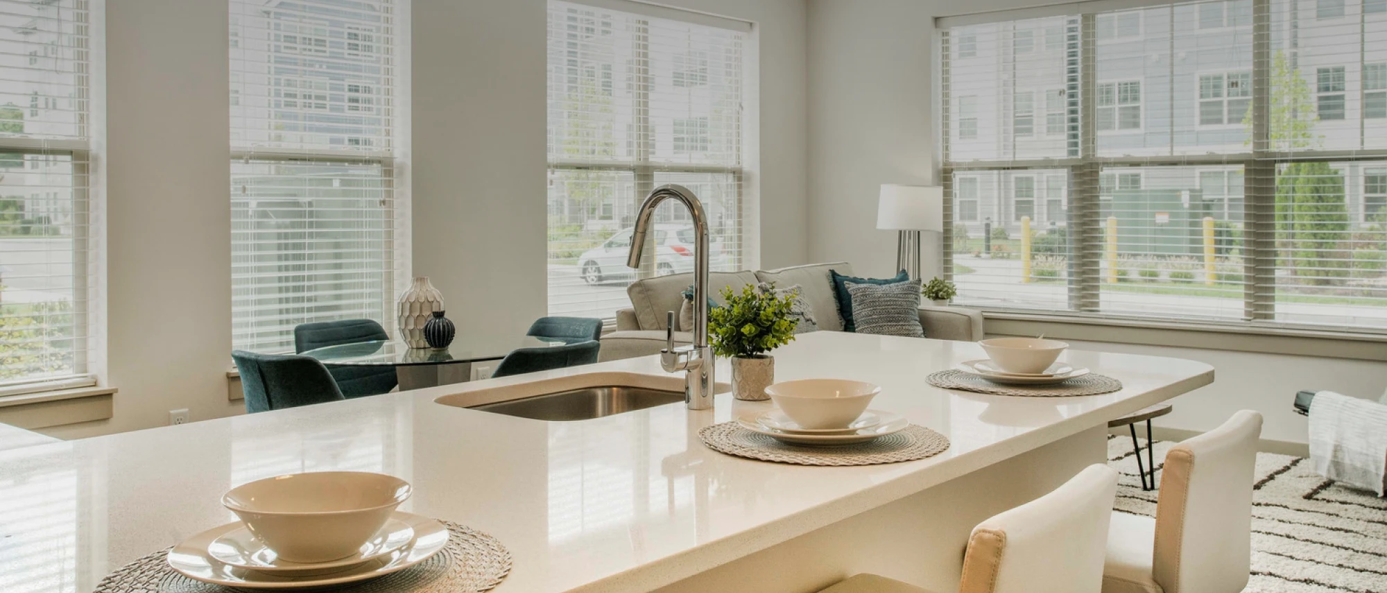 Open-concept layout featuring modern kitchen island, cozy lounge, and abundant natural lighting