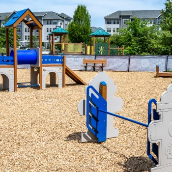 Colorful wooden play set with safety features for children, nestled in a wooded area