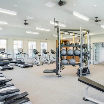 Bright indoor fitness center with cardio equipment, weight machines, and open workout space