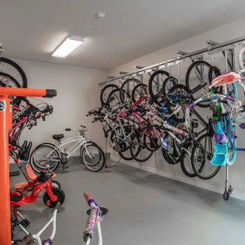 Organized indoor bike storage area with multiple bicycles hanging from wall-mounted racks
